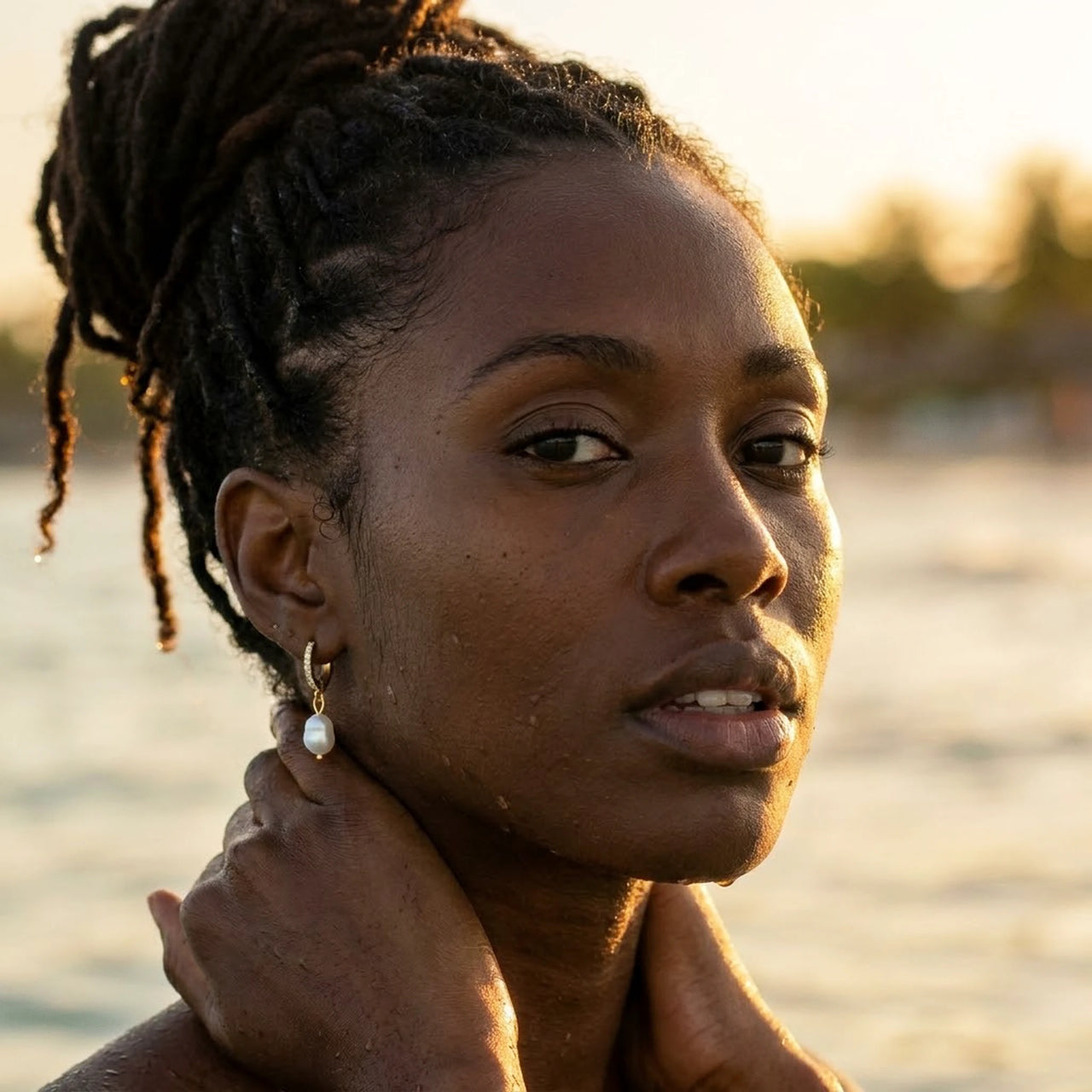 Pearl Drop Huggie Hoops in Gold, worn in the sea, wet skin | SKU: 41003-gold