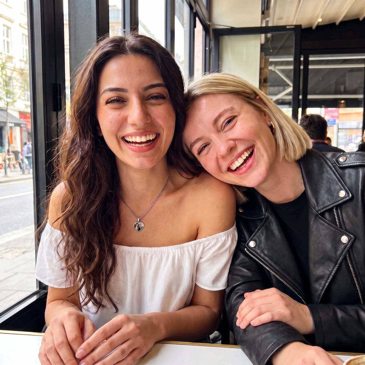 Two best friends laughing together, one wearing the silver secret heart photo necklace | SKU: TPH-CHTN-SILVER-SMALL