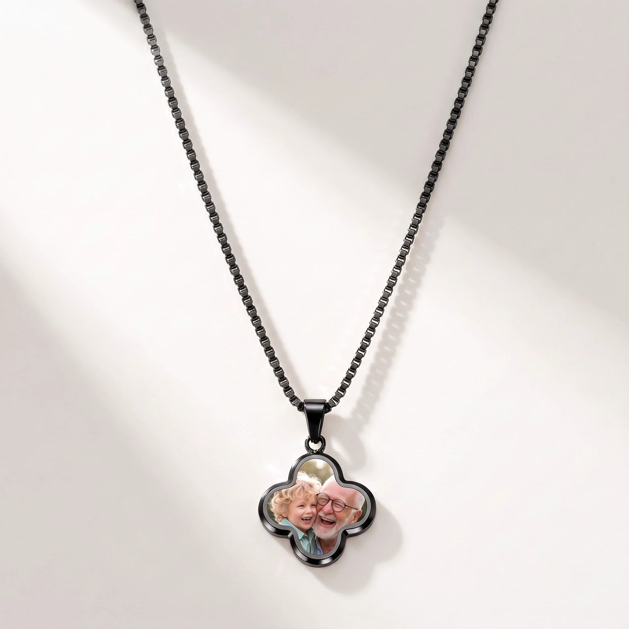 Secret Clover Photo Necklace in black, four-leaf clover pendant on a box chain showing the hidden photo | SKU: TPH-CLVN-BLACK