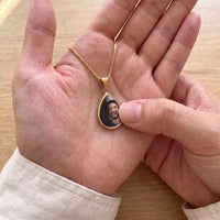 Thumbnail for Thumb warming the gold teardrop pendant: the hidden photo appears under the thumb while the rest stays black | SKU: TPH-DRPN-GOLD