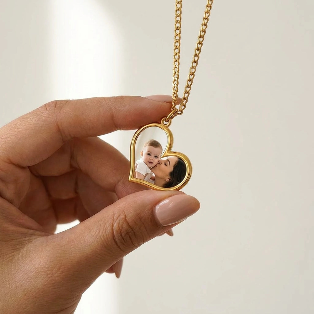Secret heart photo pendant held between two fingers, showing its real small size | SKU: TPH-HRTN-GOLD