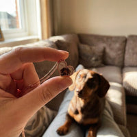Thumbnail for Customer photo: the rose gold secret heart necklace with her dachshund's photo, her dog behind | SKU: TPH-HRTN-ROSEGOLD
