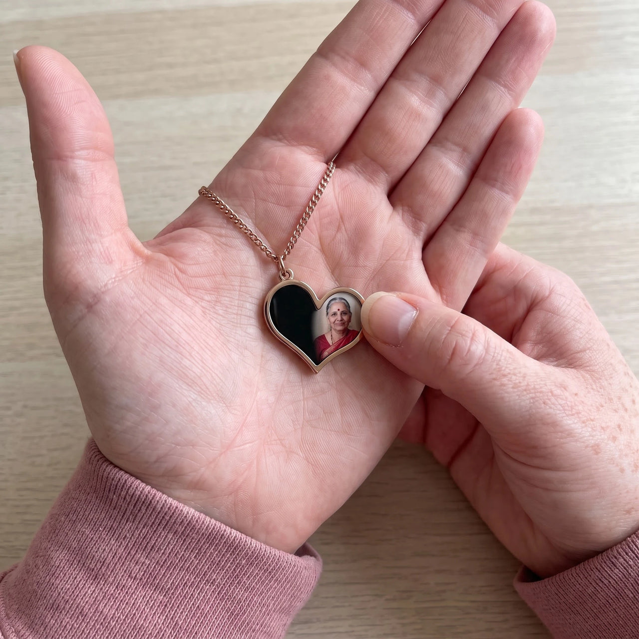 Thumb warming the rose gold heart pendant: the hidden photo appears under the thumb while the rest stays black | SKU: TPH-HRTN-ROSEGOLD