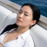 Thumbnail for Tiny Huggie Hoops in Silver, worn on a yacht | SKU: 41002-silver