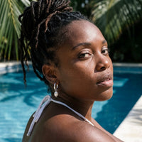 Thumbnail for Twisted Pearl Drop Hoops in Silver, worn by a tropical pool | SKU: 41004-silver